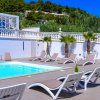 Piscina con lettini e palme nei pressi.