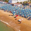 Spiaggia con file di ombrelloni blu.