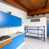 Cucina con armadietti blu e letti a castello.