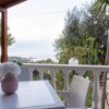 Tavolo con vaso di fiori su balcone con vista mare.
