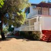 Villa bianca con scala rossa e balcone.
