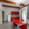 Cucina moderna con tavolo rosso e sedie abbinate.
