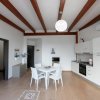 Sala da pranzo con tavolo bianco e cucina moderna.