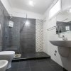 Bagno moderno con doccia e piastrelle scure.