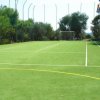 Un campo sportivo con erba sintetica e porte.