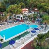 Piscina all'aperto con lettini e ombrelloni blu.